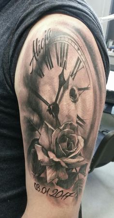 a man with a clock and rose tattoo on his arm