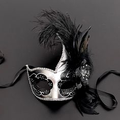 The swan-inspired black/silver mask for women has arching feathers. Silver Masks And Prosthetics For Mardi Gras Theater, Silver Costume Accessories For Halloween Masquerade, Silver Masks And Prosthetics For Carnival Costume, Silver Masquerade Accessories For Halloween, Silver Masks And Prosthetics For Theater And Carnival, Silver Theater Mask For Carnival, Silver Masks For Theater And Carnival, Elegant Silver Masks And Prosthetics For Costume, Silver Halloween Masquerade Costume Accessories