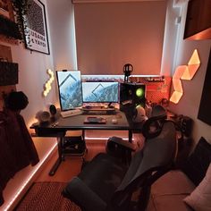 a computer desk with two monitors and a keyboard on top of it in a room