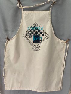 an apron with the words coffee on it and a checkerboard design in blue