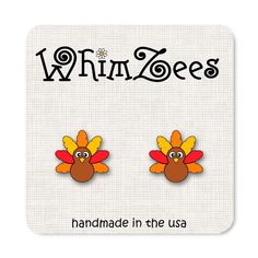 a pair of turkey earrings with the words whimzees on it's side