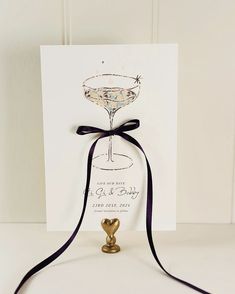 a card with a wine glass on it and a ribbon tied around the front of it