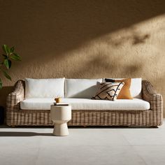 a couch sitting on top of a white tiled floor next to a potted plant