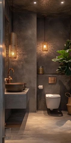 a bathroom with a toilet, sink and potted plant