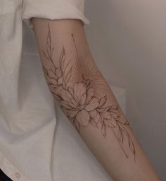 a woman's arm with a flower tattoo on the left side of her arm