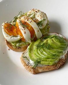 an open face sandwich with avocado and hard boiled eggs on top, topped with dill