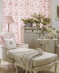 a chair and ottoman in a room with pink flowers