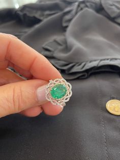 A thoughtful gift for the May birthday girl. This gorgeous birthstone ring showcases an Oval cut natural emerald center stone wrapped in yellow gold and a sparkling white diamond-lined halo. A braided pave frames the center stone crafting a flower design for extra shine and sparkle. Dazzle your friends and family on every occasion by wearing this unique, feminine, handmade piece. Available in sizes, send us yours! 2.48 carat oval natural Emerald - GRS certificate