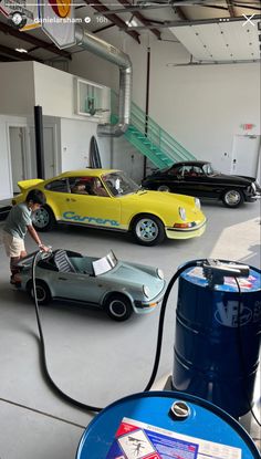 two cars are parked in a garage and one is being charged