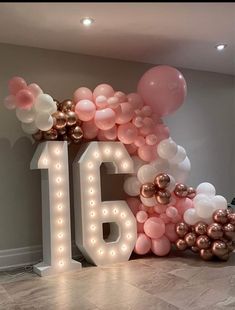 a large balloon arch with the number sixteen surrounded by balloons