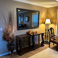 a living room filled with furniture and a large mirror on the wall over a table