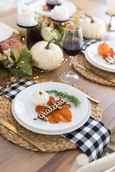 a table set for thanksgiving with pumpkins, gourds and leaves on it