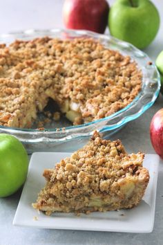 an apple pie with one slice cut out on a plate next to the rest of the pie