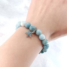 Experience the calming energy of the ocean with our Ocean Starfish Larimar Beaded Bracelet. This beautiful bracelet features a Larimar beaded strand, known for its soothing and healing properties, and is adorned with a charming starfish pendant charm made of solid 925 sterling silver. Add a touch of elegance and serenity to your wardrobe. Materials: Larimar, 925 sterling silver You can choose the option with the starfish charm or without the starfish charm. Jewelry Care: See more information about how to care for your jewelry here. Shipping Policy: Orders will be shipped within 1-3 business days. Economy shipping will take 7-14 days to arrive and standard shipping is 1- 4 days for U.S. orders. International shipping time is depended on the country and per shipping method. Shipping cost wil Turquoise Starfish Beaded Bracelets, Ocean-inspired, Turquoise Beaded Bracelets With Starfish Charm, Ocean-inspired Turquoise Starfish Beaded Bracelets, Ocean-inspired Turquoise Bracelet With Starfish Charm, Turquoise Ocean-inspired Bracelet With Starfish Charm, Ocean Starfish, Starfish Pendant, Silver Jewelry Earrings, Handmade Fashion Jewelry