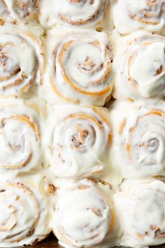 cinnamon rolls with white icing on top in a baking pan ready to be baked