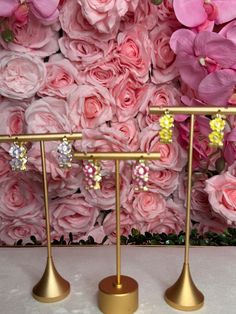 two gold stands with pink flowers behind them