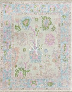 an antique rug with floral design and monogrammed initials on the center, in pastel colors