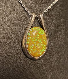 "Sunny Yellow-Orange Opal Necklace, 13x18mm Lab Created Opal, See Video For Yellow, Green And Touch Of Lavender Fire! Sleek 925 Sterling Silver Pendant Rhodium Plated 18\" Sterling Silver Chain. Chain Length Options Available By Messaging Seller At Time Of Purchase. Gift Box Included." Orange Round Pendant Jewelry For Formal Occasions, Orange Oval Necklace For Gift, Orange Oval Sterling Silver Jewelry, Orange Oval Jewelry With Polished Finish, Orange Sterling Silver Jewelry For Anniversary, Oval Orange Polished Jewelry, Sterling Silver High Luster Jewelry Gift, Orange Polished Finish Jewelry For Gift, Orange Oval Sterling Silver Necklace