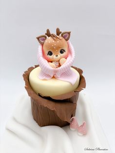 a cupcake with a baby doll sitting on top of it