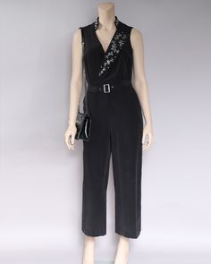 Feminine and effortless Silk Crepe de Chine Jumpsuit in size 6 only. 100% Silk Crepe. Deep V neckline with silver embellished lapel and collar stand. Center back zipper. Wide flowing leg. Self fabric belt Loops with metal buckle. Unlined. Model is 5’9”, wearing size 6. Inseam length 25" V-neck Embellished Jumpsuits And Rompers For Evening, Elegant Embellished Jumpsuits And Rompers For Cocktail, Elegant Embellished Cocktail Jumpsuits And Rompers, Elegant Embellished Sleeveless Jumpsuits And Rompers, Chic Embellished Formal Jumpsuits And Rompers, Formal Chic Embellished Jumpsuits And Rompers, Elegant Spring Jumpsuits And Rompers With Belt Loops, Chic Embellished Jumpsuits And Rompers For Formal Occasions, Elegant Belted Jumpsuits For Night Out