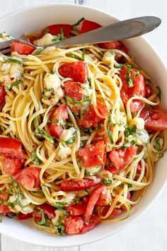 a white bowl filled with pasta and tomatoes