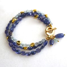 Glittering, vibrantly hued genuine polished natural periwinkle hued tanzanite, one of the rarest and most prized of all gemstones, sparkles on this strand in a beautiful bright striking splash of color! A linked strand of silvery blue baroque pearls pick up the colors of the tanzanite. A 14k gold lobster clasp secures this one of a kind piece at 7 - 8.5 inches long, however further adjustments can be made, please inquire. Blue Bracelet With Gemstone Accents As Gift, Luxury Blue Bracelets With Gemstone Accents, Blue Bracelets With Gemstone Accents As A Gift, Blue Bracelets With Gemstone Accents For Gift, Blue Faceted Amethyst Jewelry, Faceted Blue Amethyst Jewelry, Elegant Blue Amethyst Gemstones, Blue Tanzanite Bracelet Jewelry, Tanzanite Gemstone Bracelet Jewelry