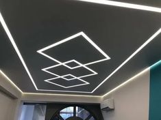 the ceiling is decorated with white lights and square shapes on black, gray, and white walls