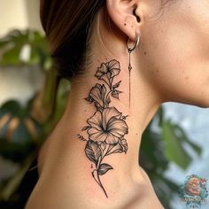 a woman's neck with a flower tattoo on it