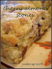 a close up of a piece of food on a plate with the words cherry almond scones