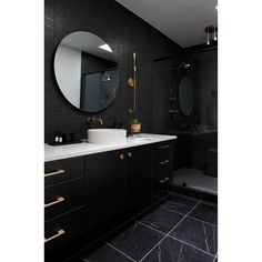 a black and white bathroom with gold accents on the sink, mirror, and bathtub