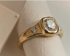 a gold ring with two diamonds on it