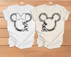 two t - shirts with mickey and minnie mouse heads on them, one is white and the other is black