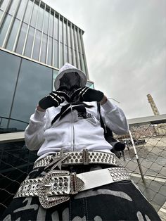 a person wearing a white hoodie and black pants is standing in front of a building