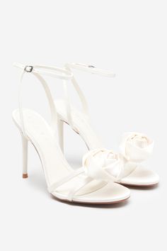 Add a sense of versatility to your wardrobe with staples like our Sweet Step stilettos. Crafted in opulent satin. these ivory lace-up heels are defined by a floral corsage that sits elegantly across the toe straps. Finished with padded soles. Sweet Step are a must-have for your next night out. Features - Premium satin - Floral corsage- Rounded toe- Buckle-fastening ankle strap- Stiletto heel - Heel height: 3.9in/10cm Product Information Designed exclusively by Club L London Premium satin in Ivor Luxury Satin Heels For Spring, White Satin Ankle Strap Heels, Spring Wedding Satin Open Toe Shoes, Elegant Satin Wedding Shoes For Spring, Chic Cream Wedding Shoes For Events, Cream Heels For Spring Events, Chic Cream Wedding Shoes For Event, Elegant White Satin Sandals, Feminine Satin Heels For Formal Occasions