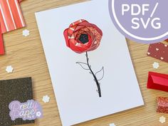 a card with a red flower on it next to some other cards and paper decorations