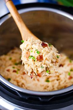 a wooden spoon in a slow cooker filled with food