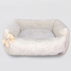 a white dog bed with a bow on it