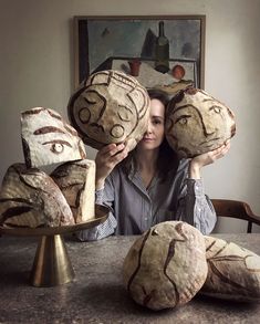 a woman sitting at a table with some baked goods in front of her face and hands