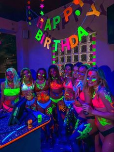 a group of young women standing next to each other in front of a neon sign