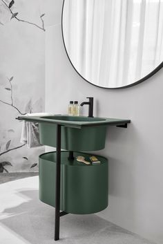 a bathroom sink with two green bins under the faucet and a round mirror above it