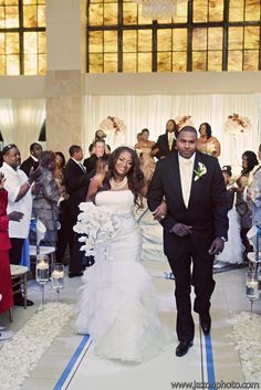 a bride and groom walking down the aisle