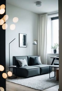 a black and white living room with lights on the wall, couches and rugs