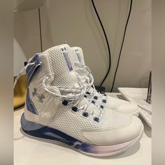 a pair of white and blue sneakers sitting on top of a table