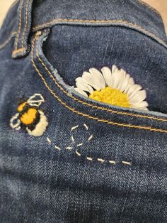 the back pocket of a pair of jeans with a daisy in it's pocket