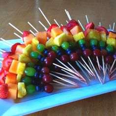 a platter filled with fruit and skewers