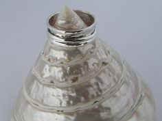 a silver vase sitting on top of a white table