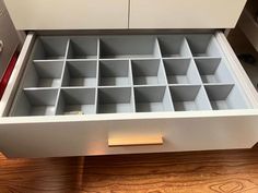 an open drawer with many compartments on it