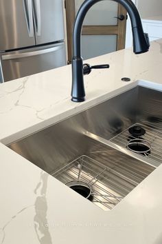 white quartz countertops with stainless steel undermount sink installed with matte black faucet and garbage disposal button Steel Kitchen Sink