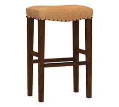 the backless stool is made from wood and has brown leather upholstered seat