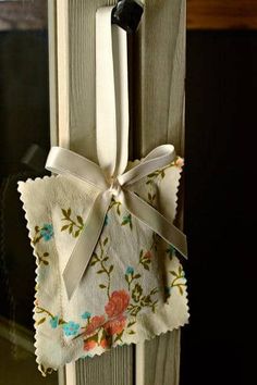 a pair of scissors hanging from the side of a window sill with flowers on it